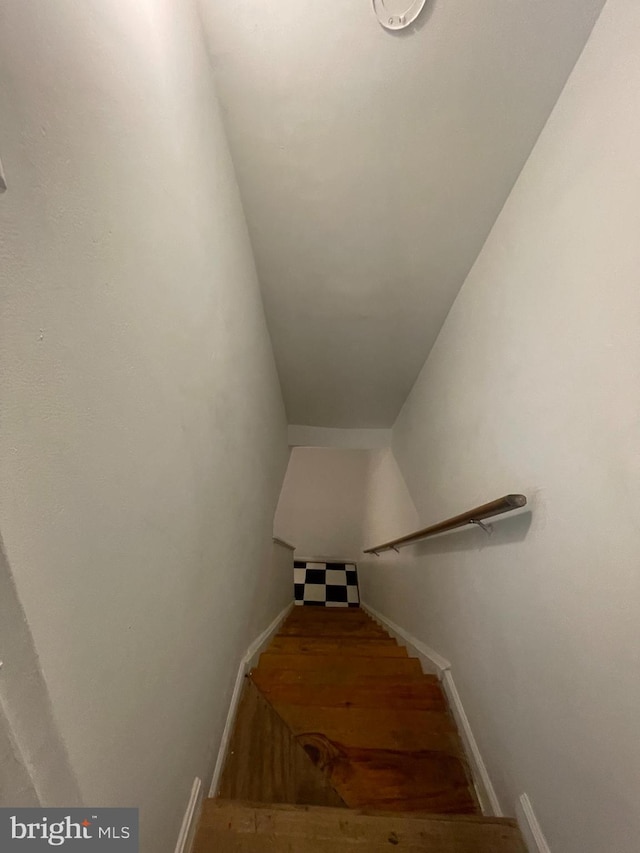 staircase with baseboards and wood finished floors