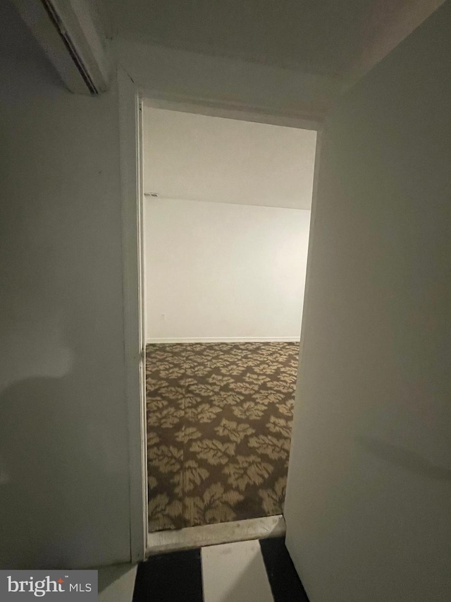 corridor with carpet and a wall mounted AC