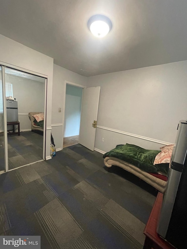 carpeted bedroom with baseboards and a closet