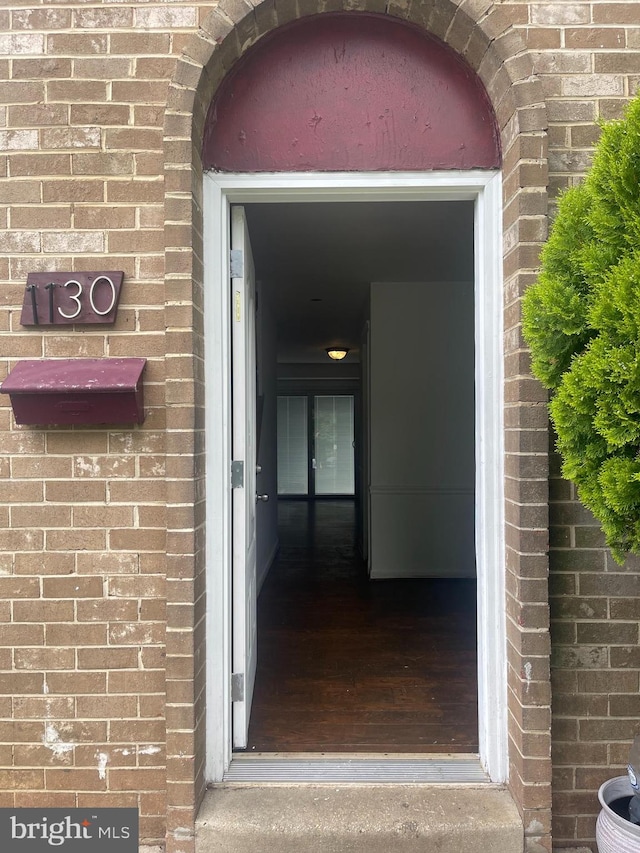 view of exterior entry featuring brick siding