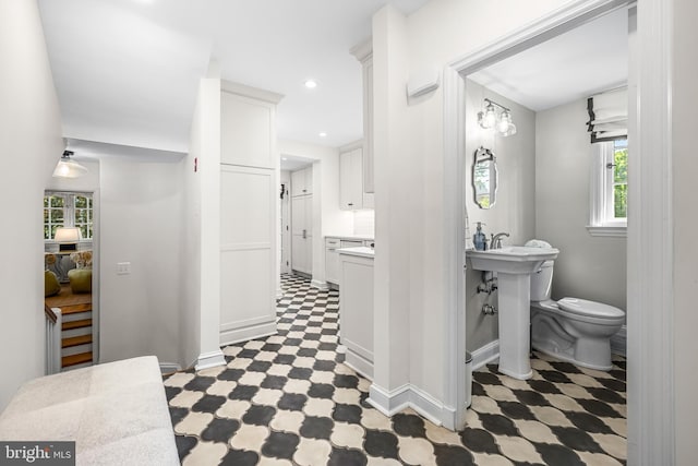 bathroom with tile patterned floors, toilet, baseboards, and recessed lighting
