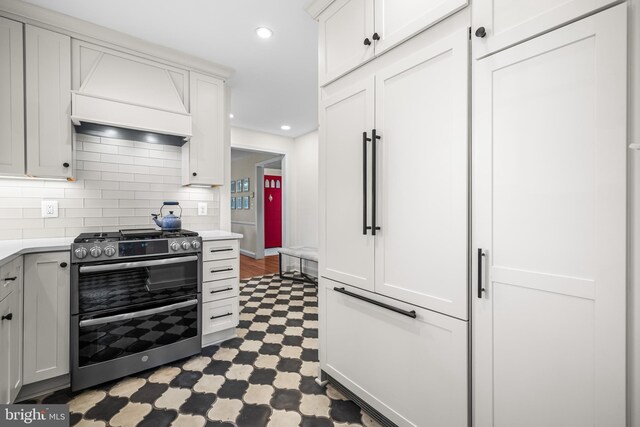 kitchen featuring double oven range, custom exhaust hood, light countertops, tile patterned floors, and recessed lighting