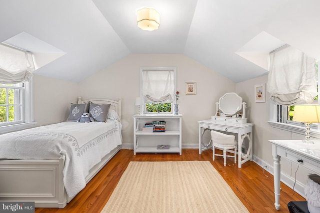bedroom with wood finished floors, vaulted ceiling, and baseboards