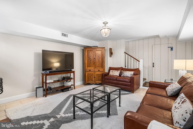 living area featuring stairs, tile patterned floors, and baseboards