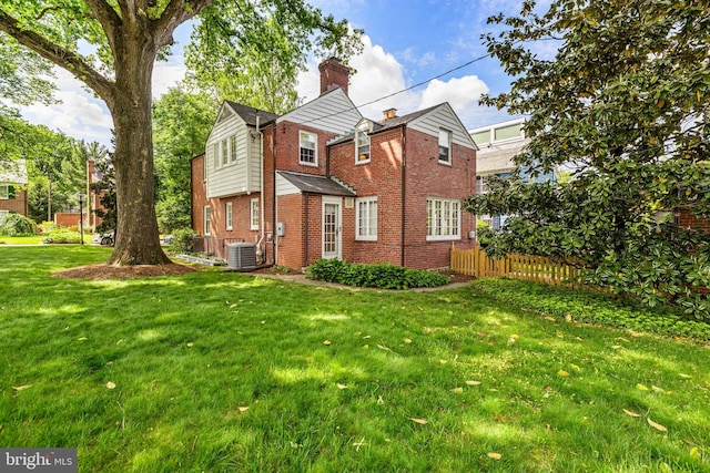 view of side of home featuring brick siding, a chimney, and central AC unit