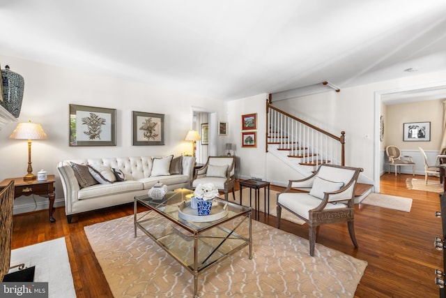 living area with wood finished floors, stairway, and baseboards