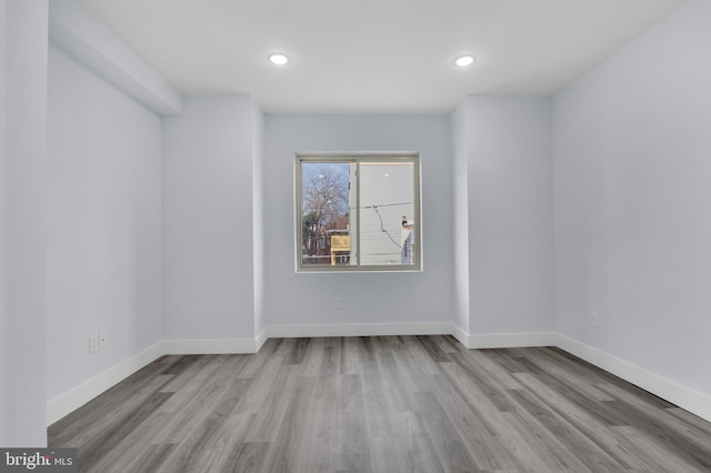 unfurnished room featuring recessed lighting, baseboards, and wood finished floors