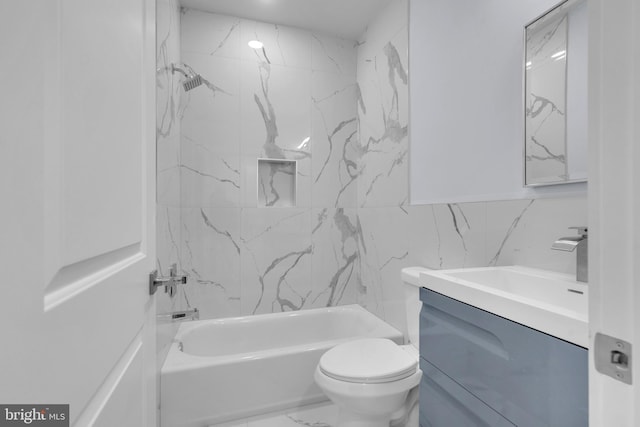 bathroom featuring vanity, marble finish floor, toilet, bathing tub / shower combination, and tile walls