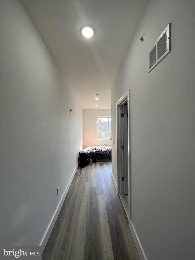 corridor with visible vents, dark wood finished floors, and baseboards