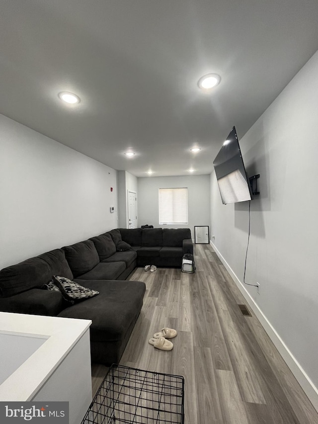 living area featuring recessed lighting, baseboards, and wood finished floors