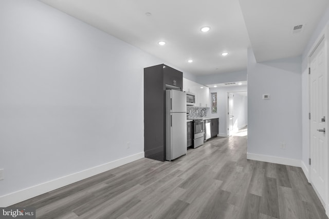 unfurnished living room featuring baseboards, recessed lighting, light wood-style flooring, and visible vents