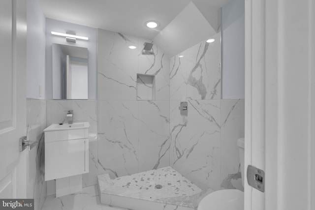 bathroom with vanity, marble finish floor, toilet, tile walls, and a marble finish shower
