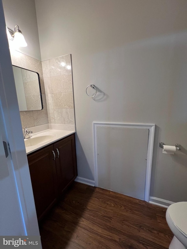 bathroom featuring vanity, baseboards, toilet, and wood finished floors