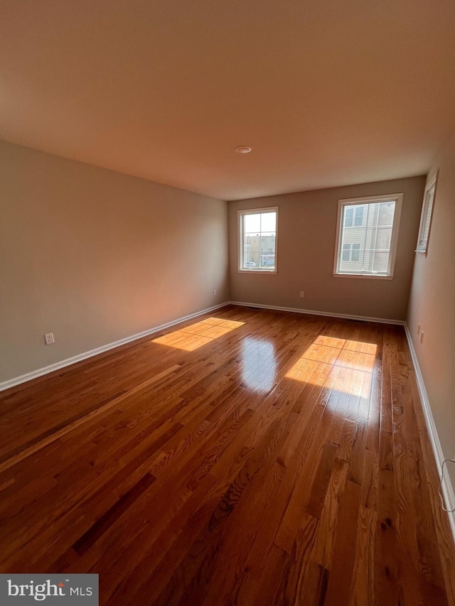 empty room featuring baseboards and wood finished floors