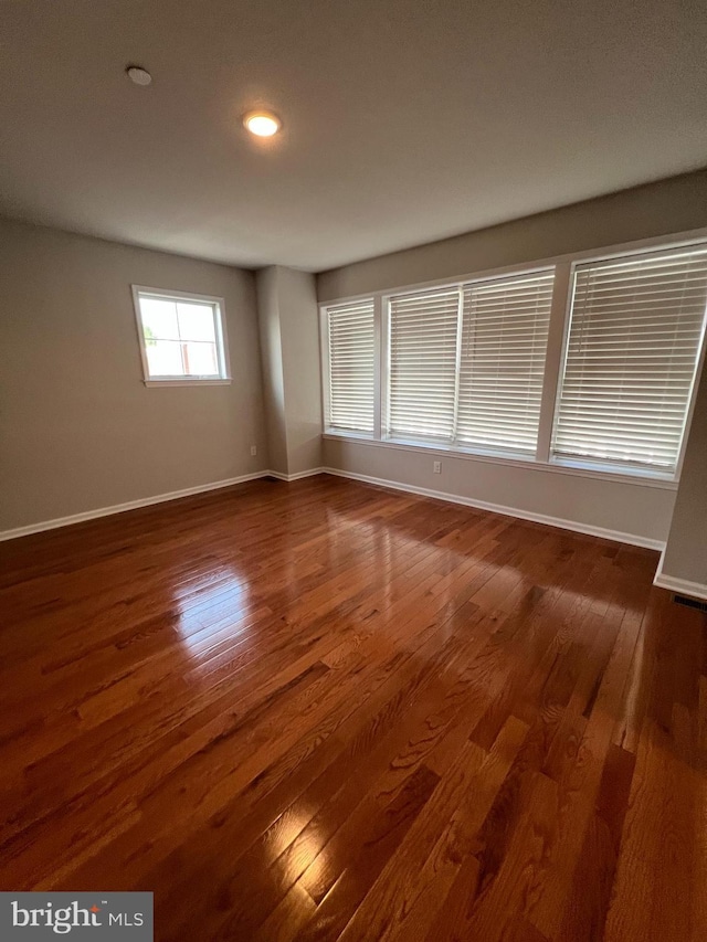 spare room with recessed lighting, baseboards, and wood finished floors