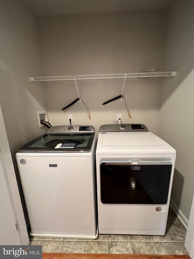 laundry area featuring laundry area, washing machine and dryer, and baseboards