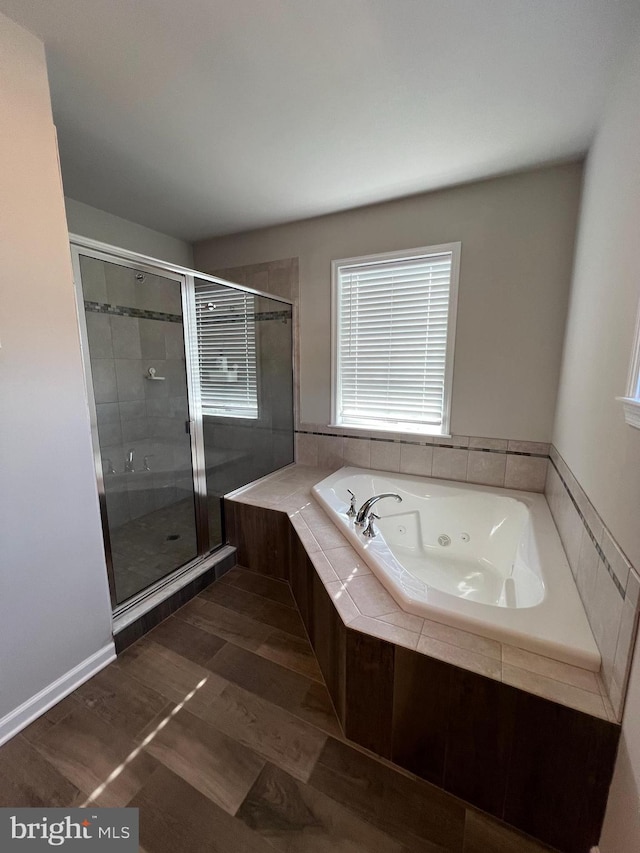 full bath featuring a stall shower, a healthy amount of sunlight, and a jetted tub