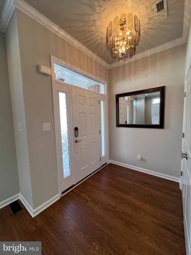 entryway with crown molding, visible vents, wood finished floors, baseboards, and a chandelier
