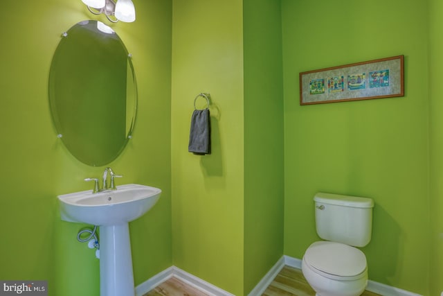 bathroom with toilet, baseboards, and a sink