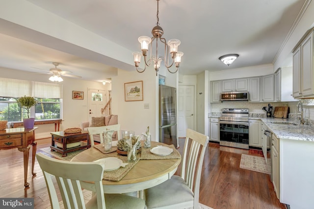 dining area with ceiling fan with notable chandelier and dark wood-style floors