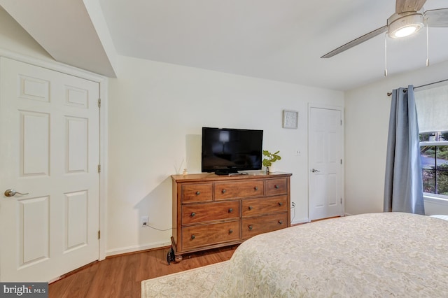 bedroom with baseboards, ceiling fan, and wood finished floors