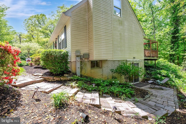 view of property exterior featuring a patio and brick siding