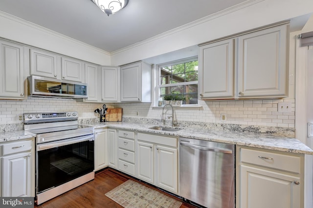 kitchen with crown molding, appliances with stainless steel finishes, tasteful backsplash, dark wood finished floors, and a sink