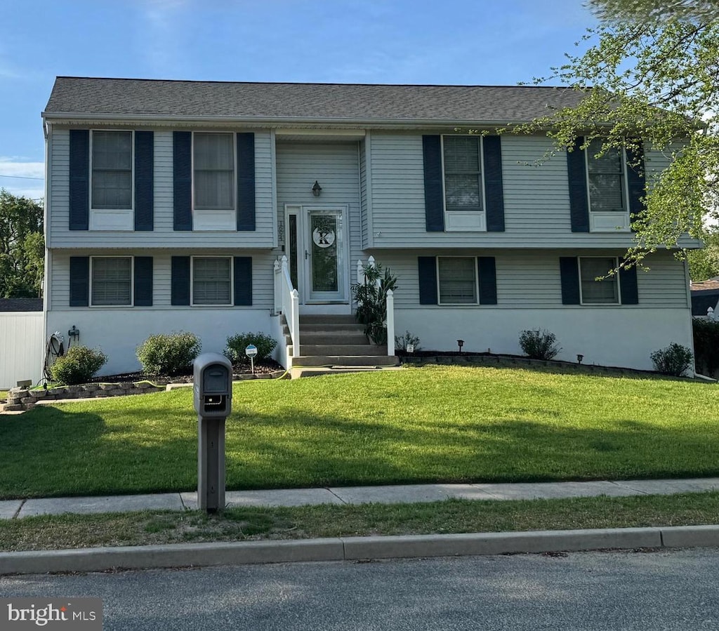 raised ranch with a front lawn