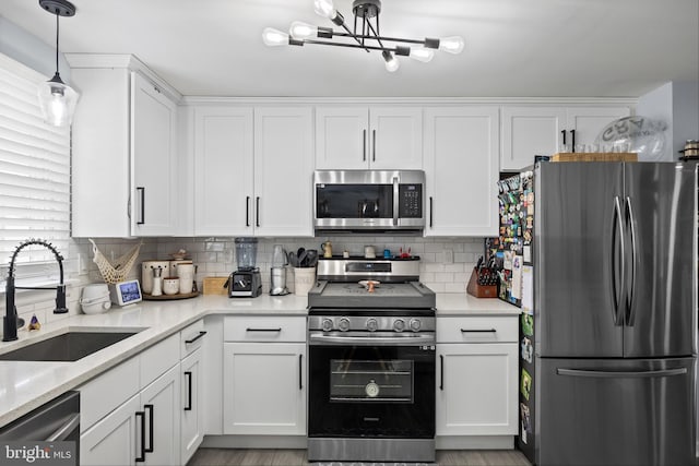 1694 Atkins Ave, Thorofare, NJ 08086 - kitchen featuring stainless steel appliances, a sink, white cabinetry, a chandelier, and backsplash