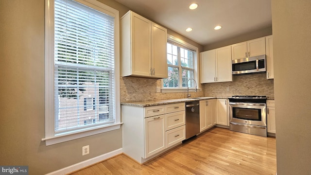 11441 Log Ridge Dr, Fairfax, VA 22030 - kitchen with appliances with stainless steel finishes, light wood-style flooring, decorative backsplash, recessed lighting, and baseboards