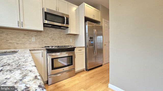 11441 Log Ridge Dr, Fairfax, VA 22030 - kitchen featuring stainless steel appliances, tasteful backsplash, light wood finished floors, and light stone counters