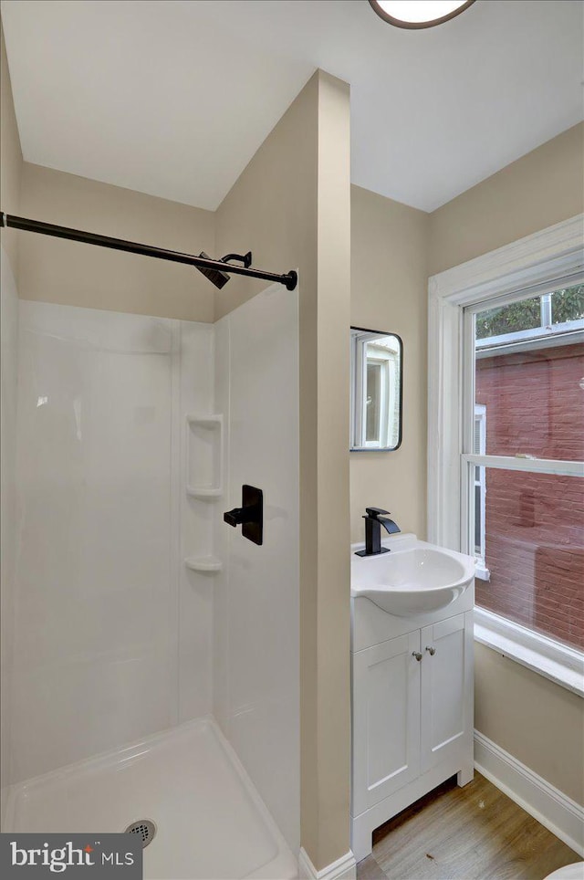 472 Atlantic Ave, Lancaster, PA 17602 - bathroom featuring wood finished floors, a shower, baseboards, and vanity