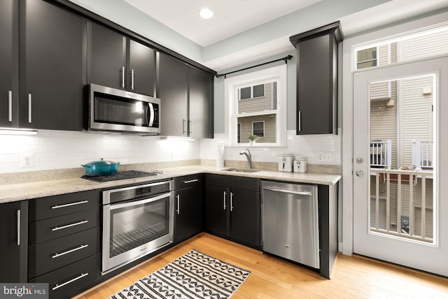 631 Regent Pl NE, Washington, DC 20017 - kitchen featuring stainless steel appliances, dark cabinetry, a sink, light wood-style flooring, and recessed lighting