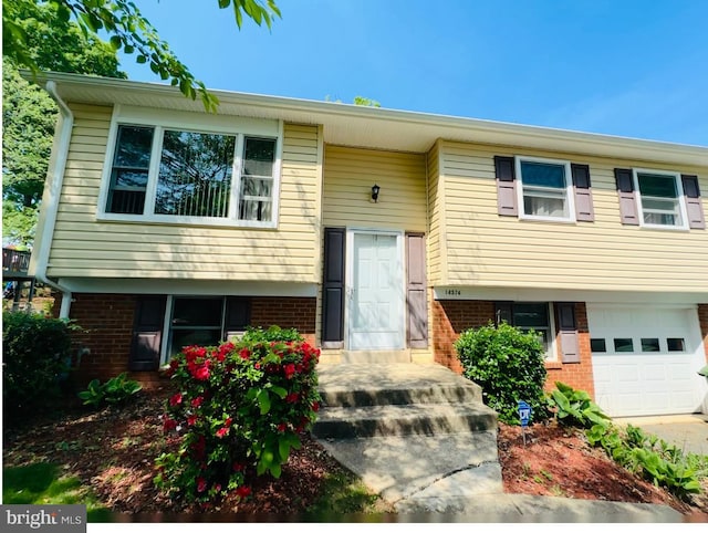 split foyer home with a garage and brick siding