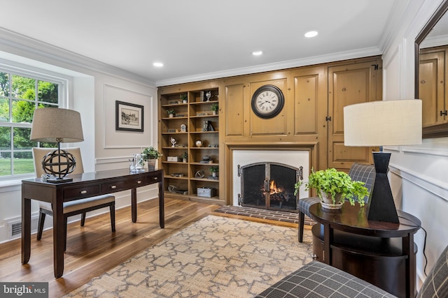 1409 Beaumont Dr, Gladwyne, PA 19035 - office space with crown molding, wood finished floors, a lit fireplace, built in shelves, and a decorative wall