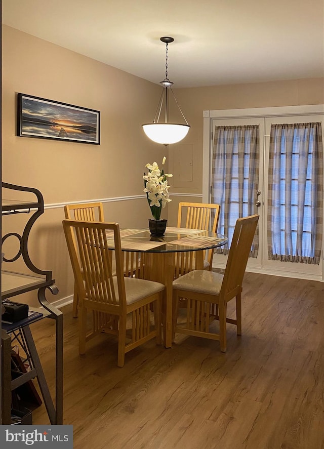 dining space featuring baseboards and wood finished floors
