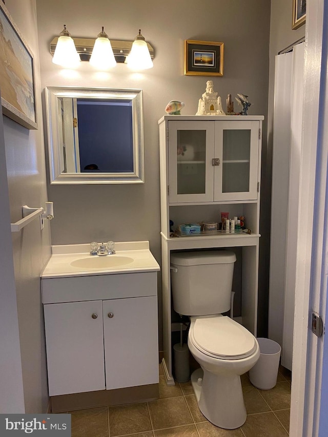bathroom with vanity, tile patterned flooring, and toilet