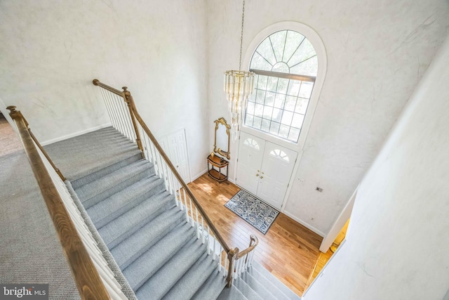entryway with wood finished floors, stairway, and baseboards
