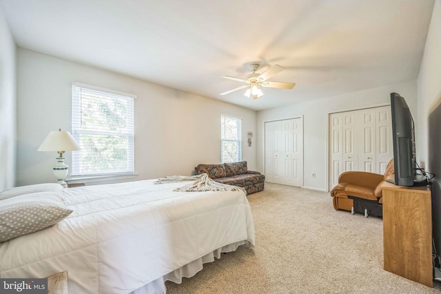 bedroom with multiple closets, carpet flooring, a ceiling fan, and baseboards