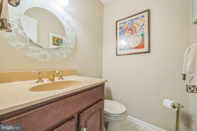 bathroom with vanity, toilet, tile patterned floors, and baseboards