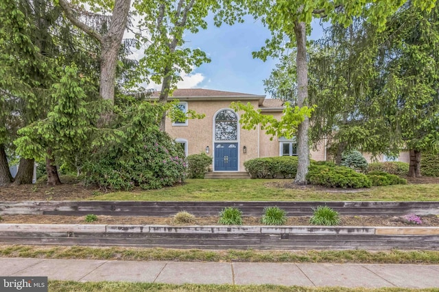 view of front facade featuring stucco siding and a front yard