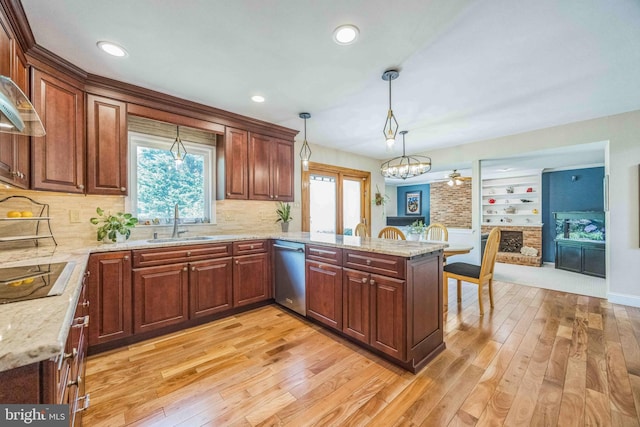 kitchen featuring dishwasher, black electric stovetop, a sink, light wood-style floors, and a peninsula