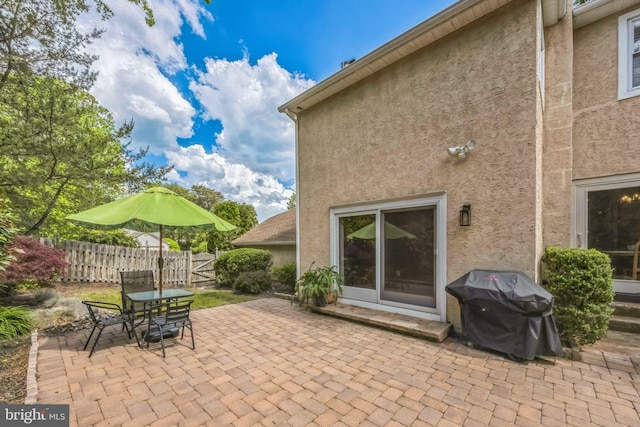 view of patio featuring area for grilling, fence, and outdoor dining area