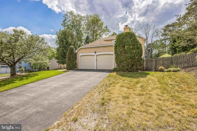 view of side of home with driveway, stucco siding, a garage, and a chimney
