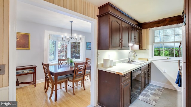 100 Lakeview Dr, Ridley Park, PA 19078 - kitchen with an inviting chandelier, dark brown cabinets, a sink, black dishwasher, and light countertops