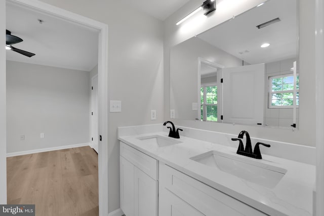 full bath with a wealth of natural light, a sink, and wood finished floors