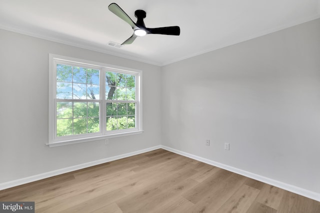 empty room with ceiling fan, ornamental molding, baseboards, and wood finished floors