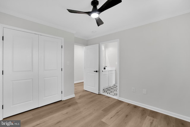 unfurnished bedroom featuring baseboards, a closet, light wood finished floors, and crown molding