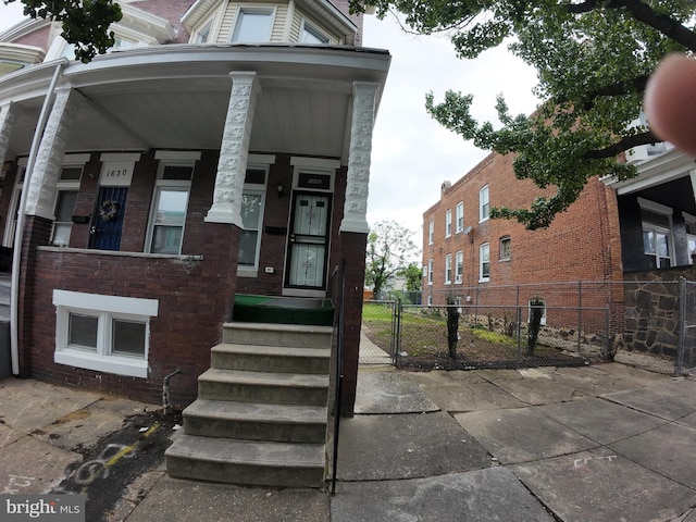 1632 Moreland Ave, Baltimore, MD 21216 - view of front facade with fence, a gate, a porch, and brick siding