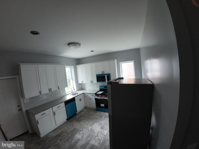 1632 Moreland Ave, Baltimore, MD 21216 - kitchen with stainless steel microwave, dishwasher, gas range oven, a sink, and white cabinetry